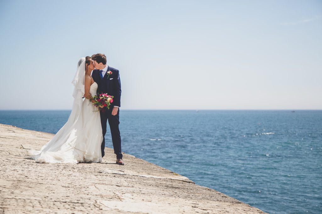 Wedding couple kissing on the Cobb in Lyme Regis, Dorset.