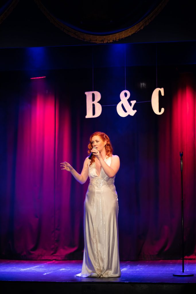 Bride singing on stage at the Marine Theatre wedding venue in Dorset.