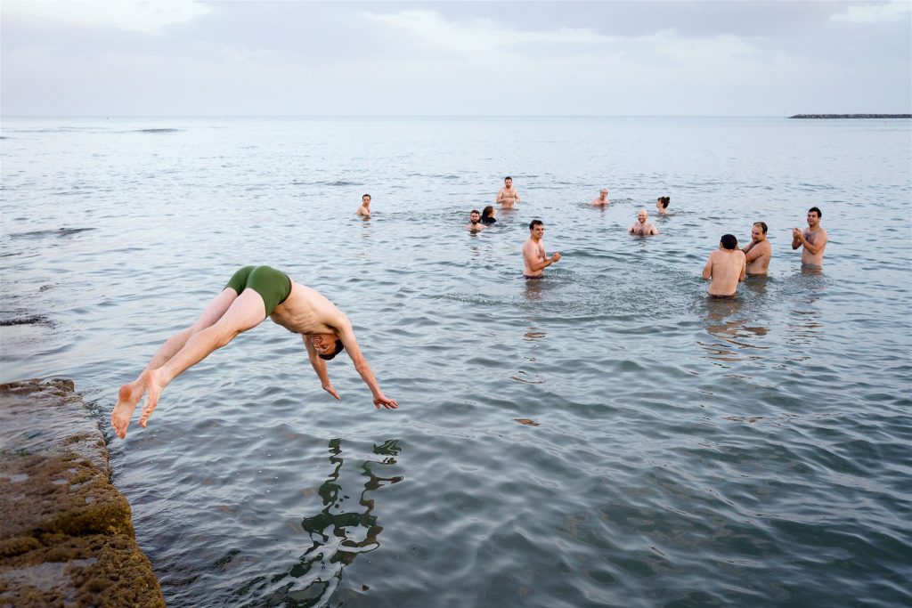 Groom dives into the sea in Lyme Regis (South West of England).