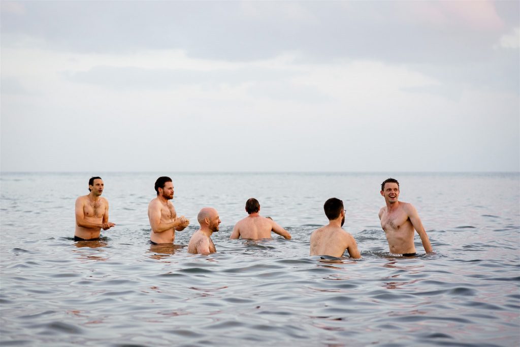 Group of men swimming in the sea in Lyme Regis (South West of England).