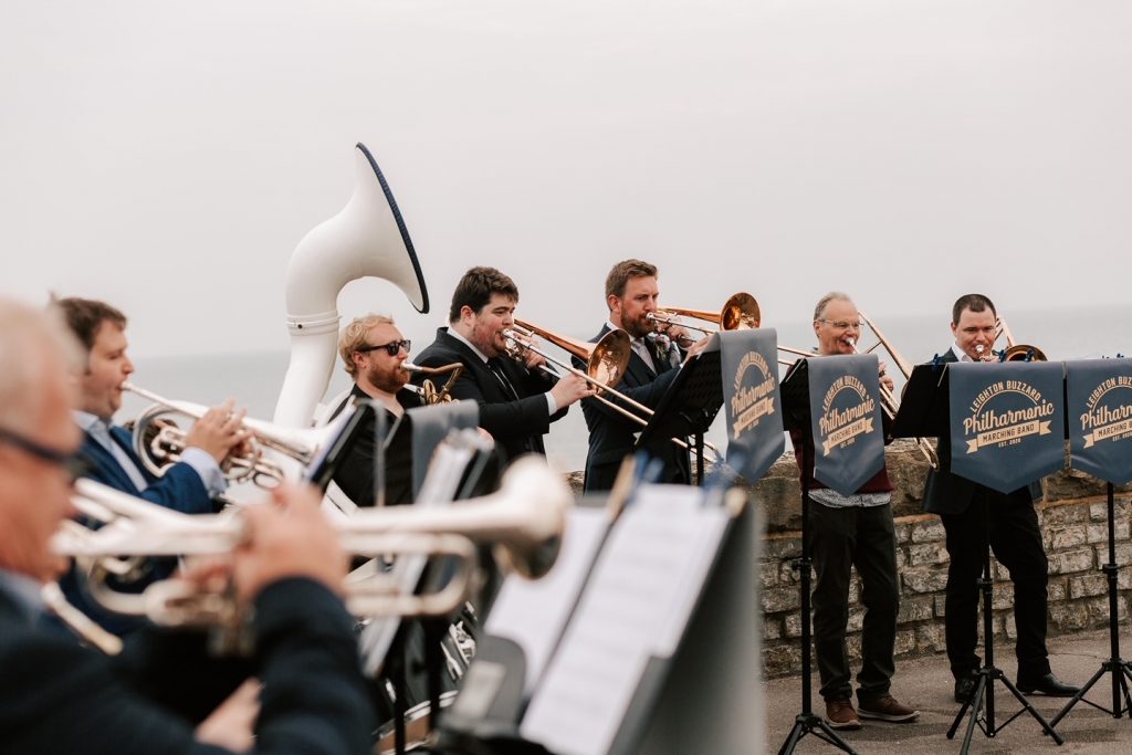 Brass band playing by the sea at a wedding in Dorset.