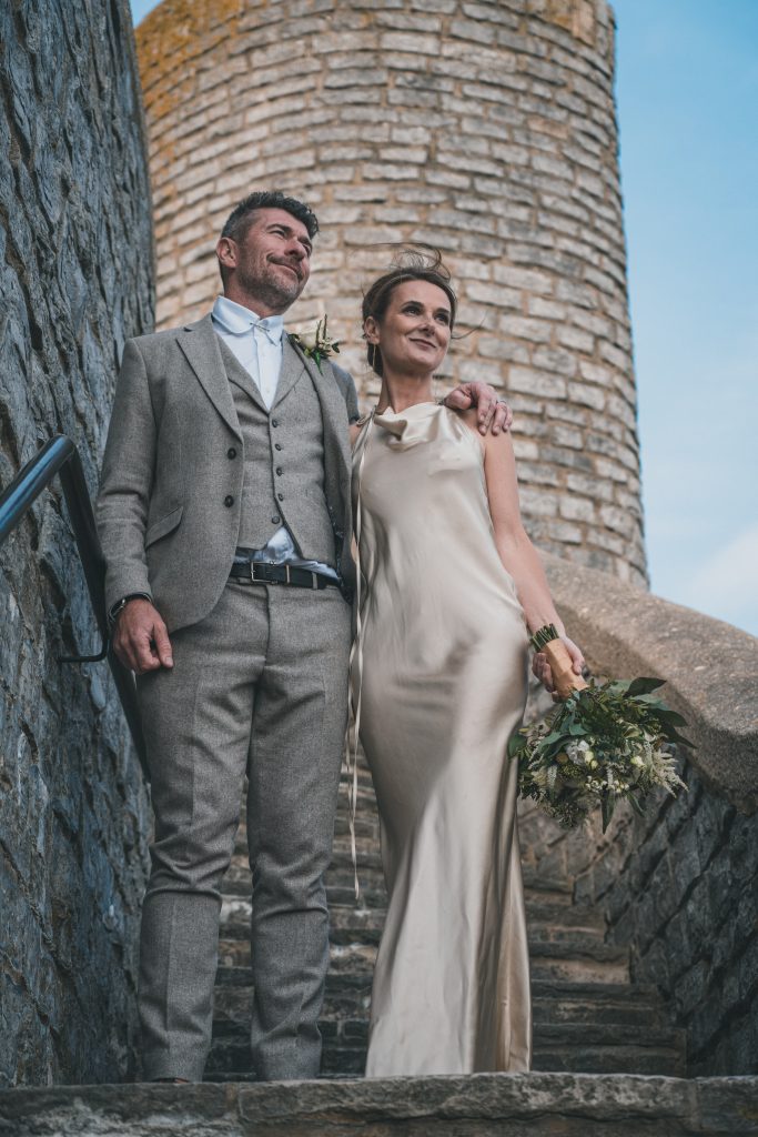 Wedding couple stood on the theatre square staircase in Lyme Regis, Dorset.