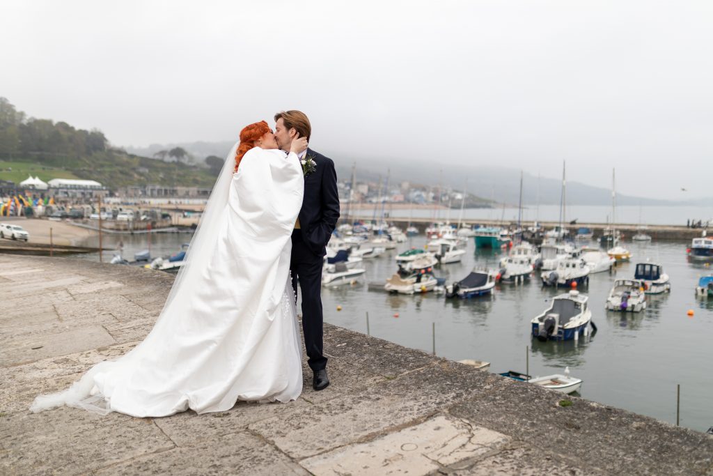 Couple kissing on the cobb in Lyme Regis - unique weddings in Dorset